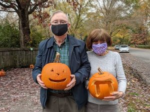 couple holding carved pumpkins