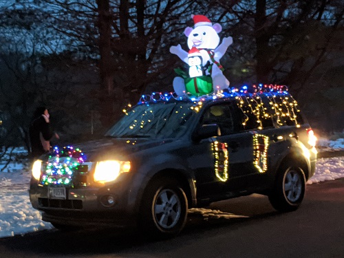 white polar bear inflatable on top of a car in the Christmas lights car parade 