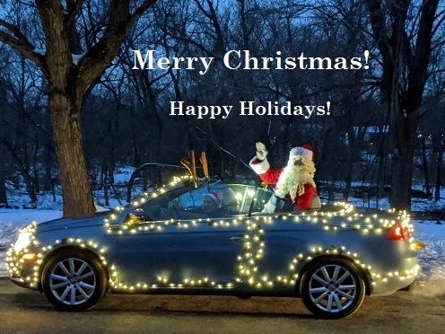 Santa in a decorated convertible with white lights