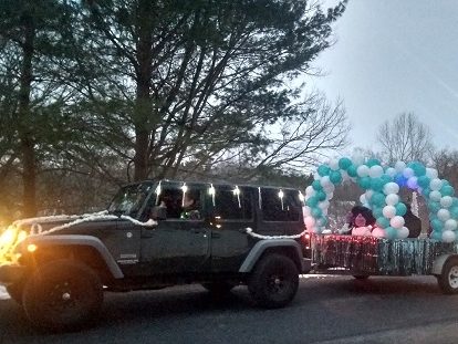 A car pulling a display of balloons in the parade